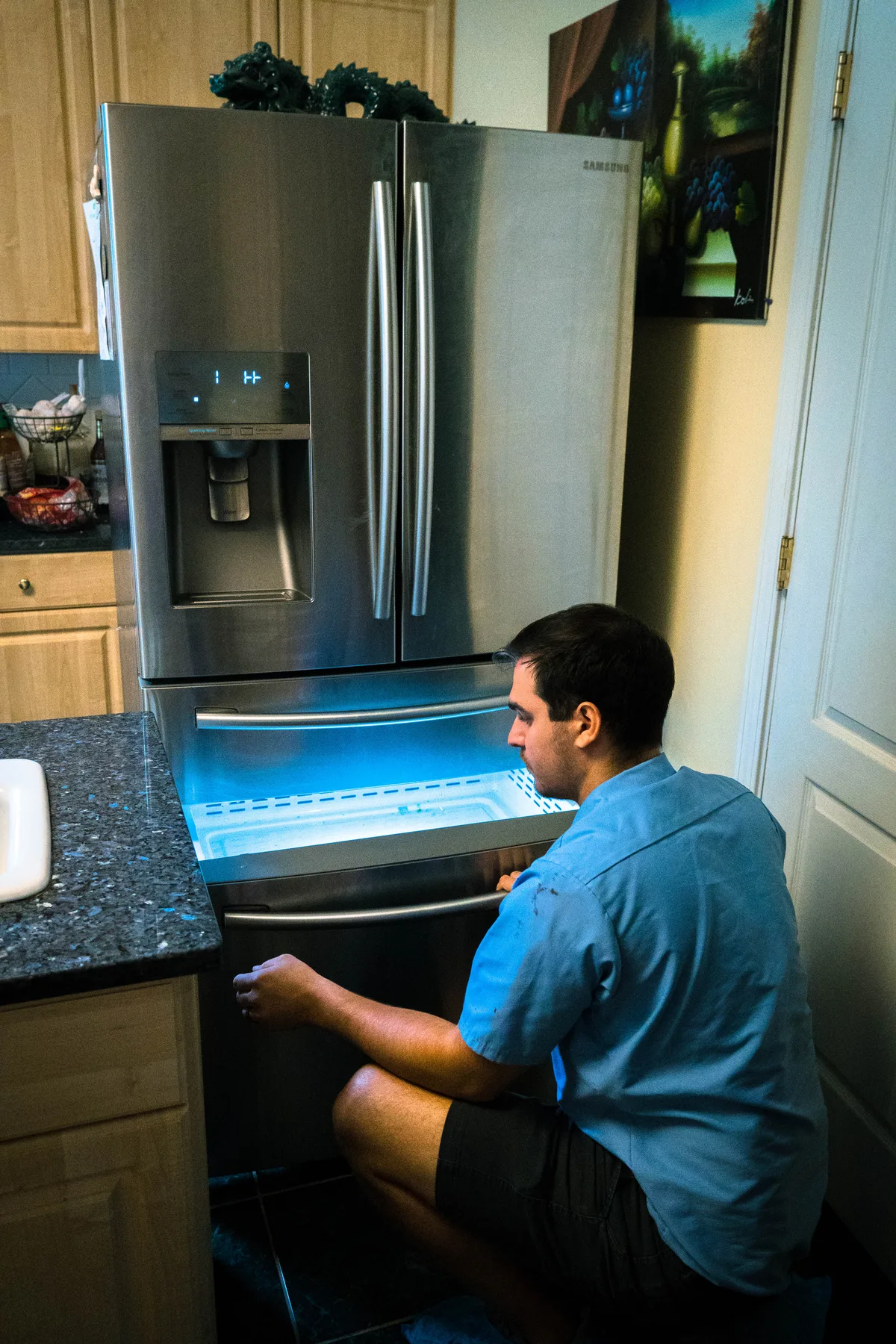 Appliance EMT technician servicing the freezer drawer of a french-door refrigerator